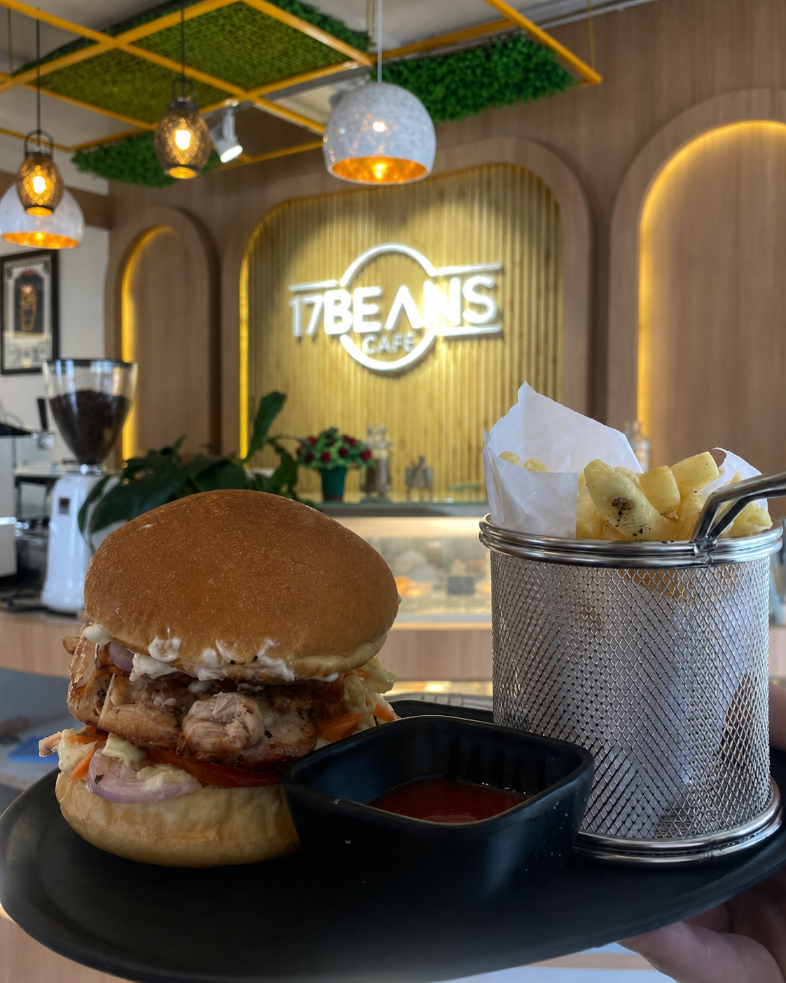 A burger and fries served in front of the 17 Beans Cafe counter